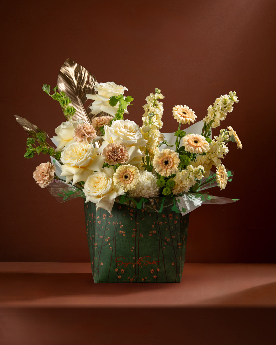 Bouquet of flowers in a decorative box on a brown background