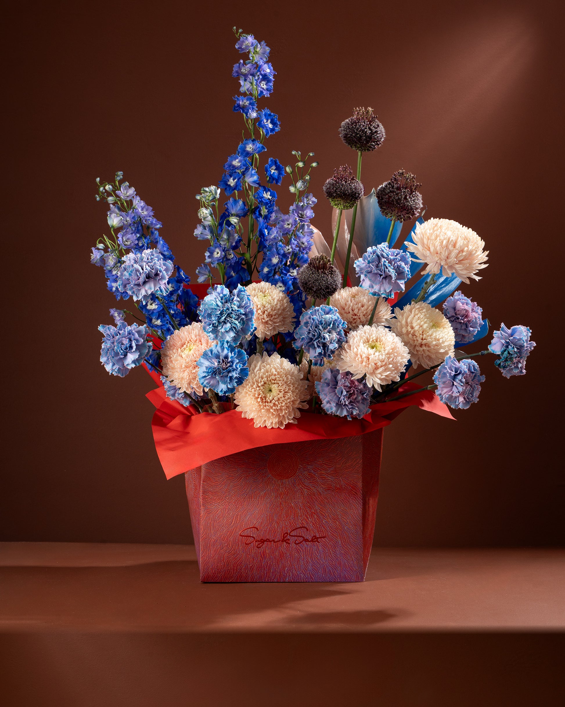 Bouquet of flowers in a red box with a brown background