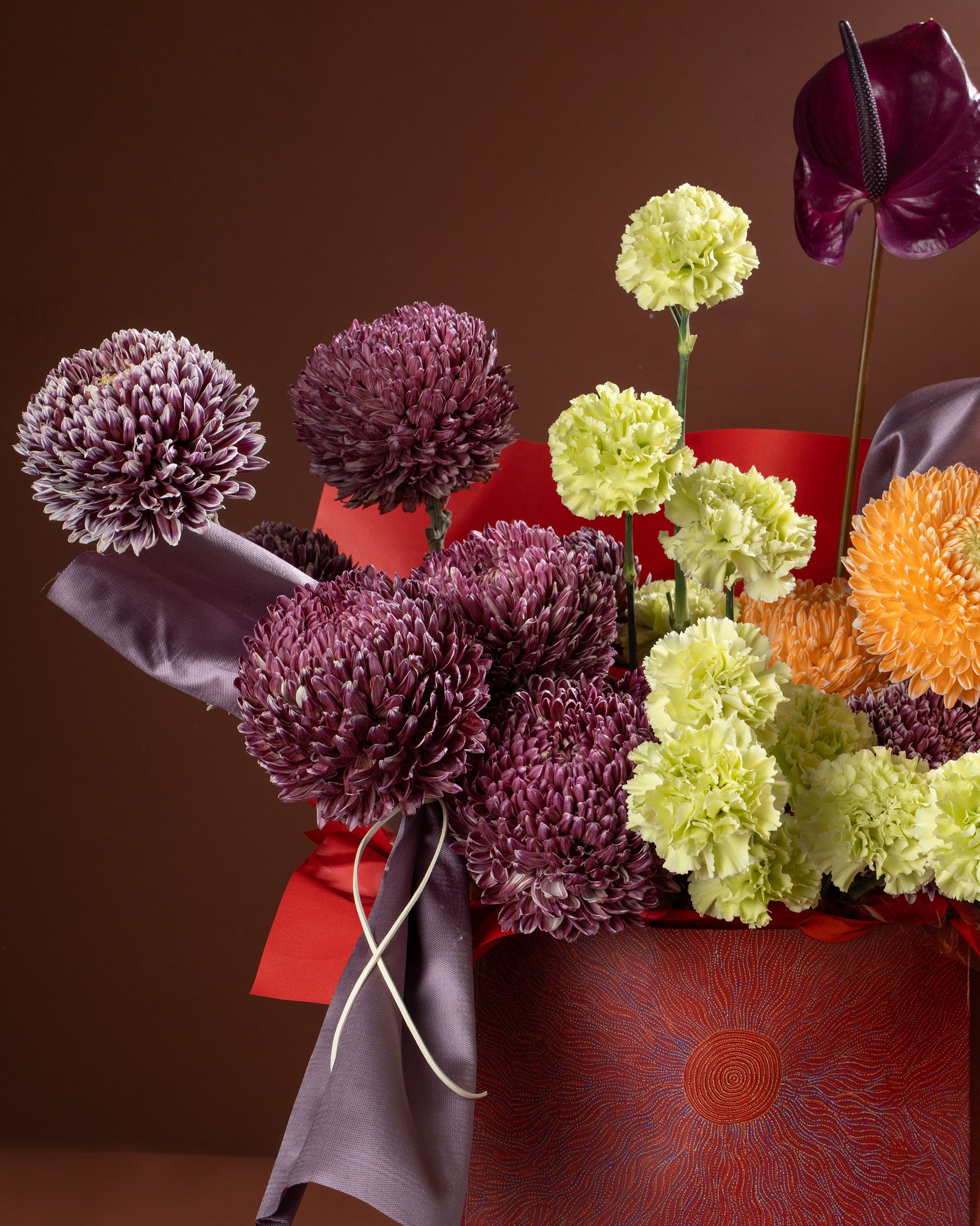Bouquet of flowers with purple, green, and orange colors on a brown background