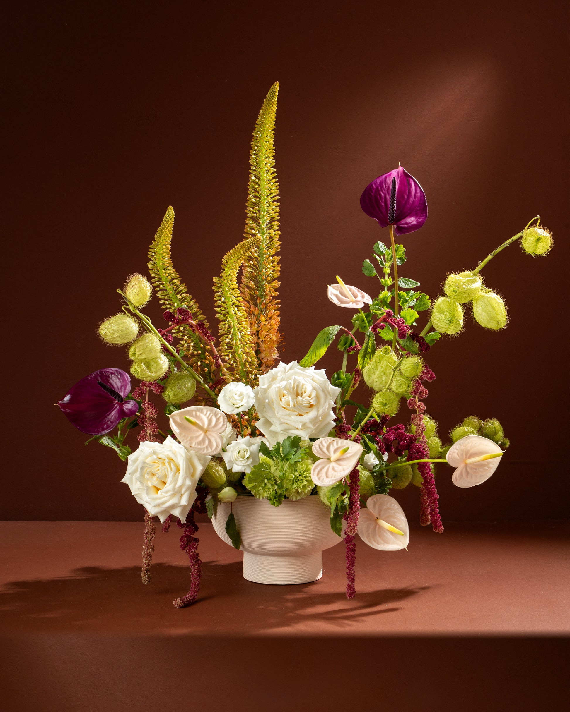 Floral arrangement in a white vase on a brown background
