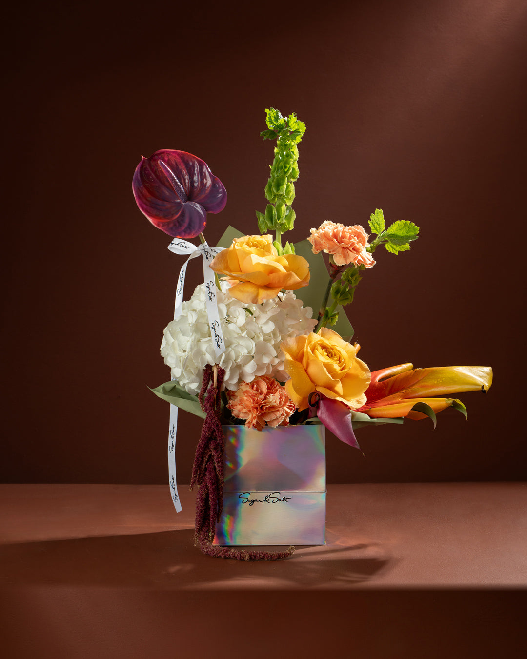 Colorful flower arrangement in a box on a brown background