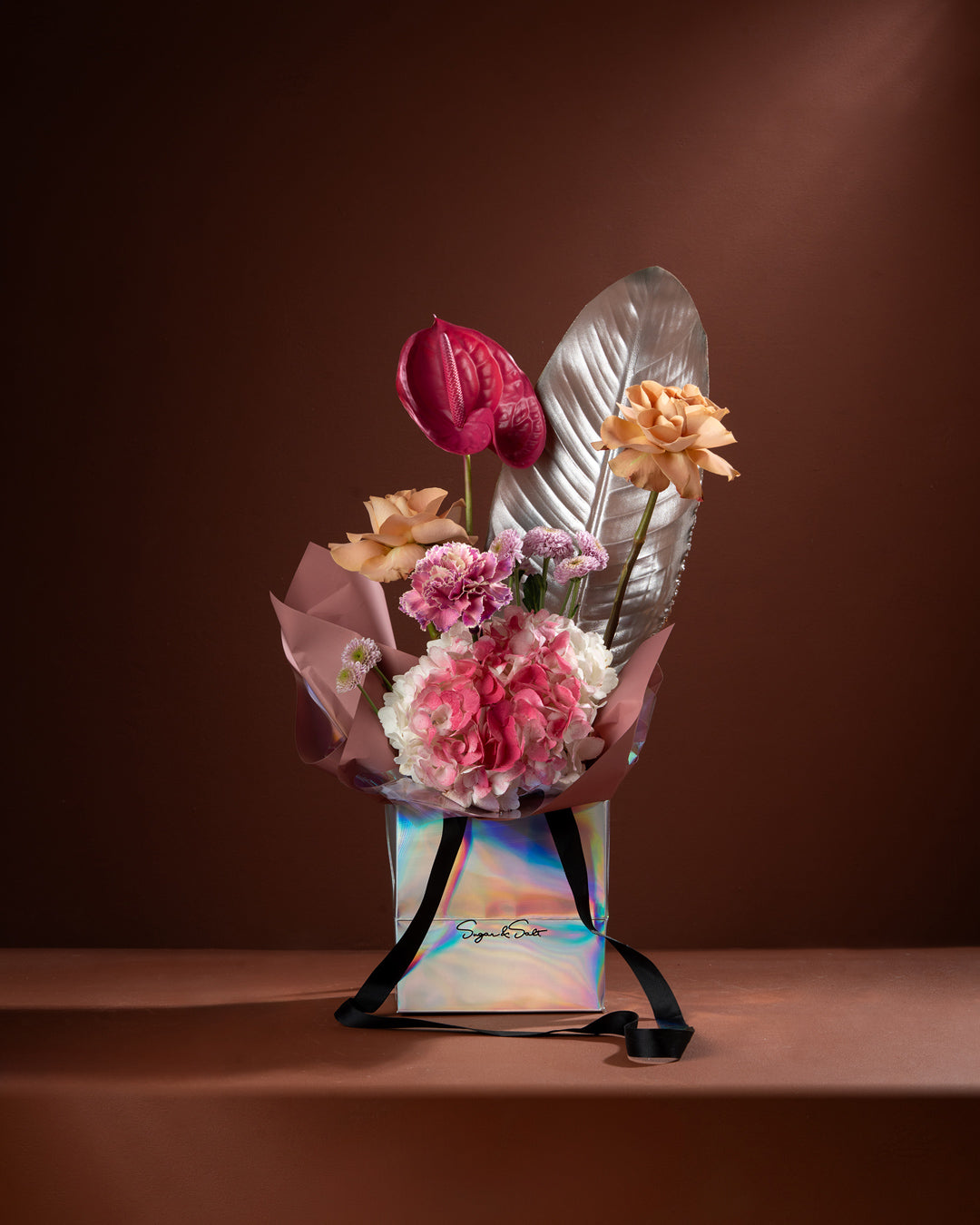 Bouquet of flowers in a decorative box on a brown background